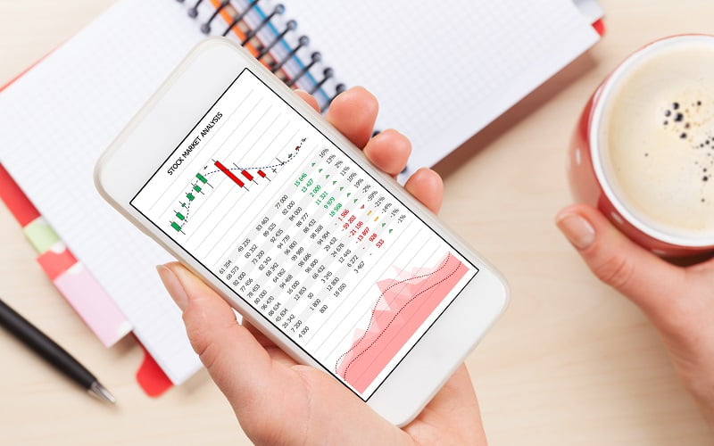 Woman holding smartphone above business desk